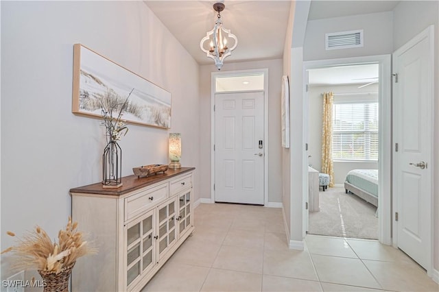 tiled entryway featuring a chandelier