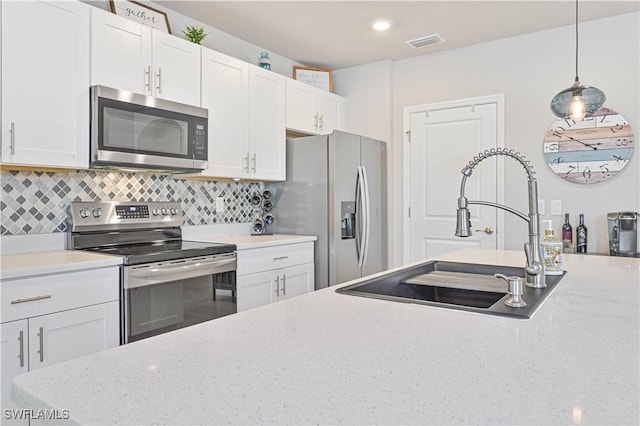 kitchen featuring white cabinetry, appliances with stainless steel finishes, sink, and tasteful backsplash