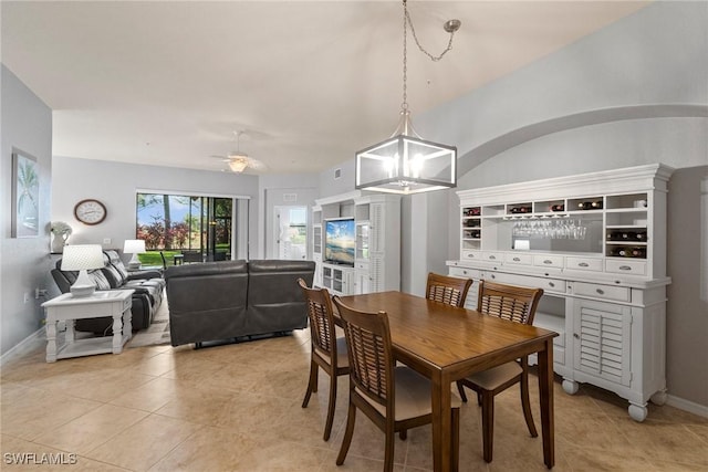 tiled dining area with ceiling fan with notable chandelier