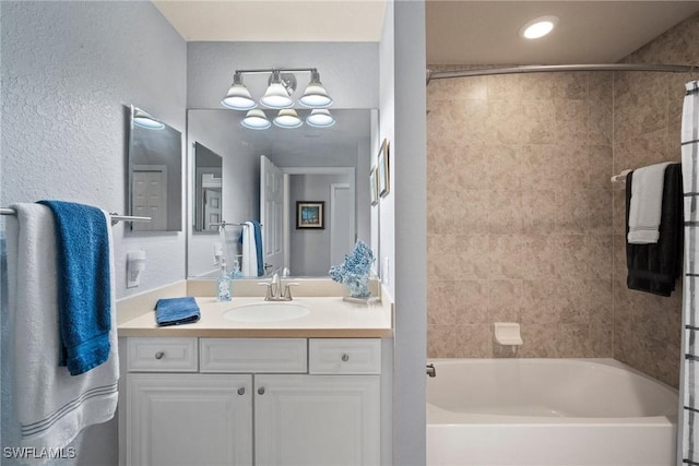 bathroom with tiled shower / bath combo and vanity