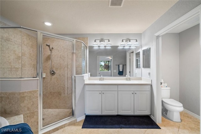 bathroom with vanity, tile patterned floors, a shower with door, and toilet