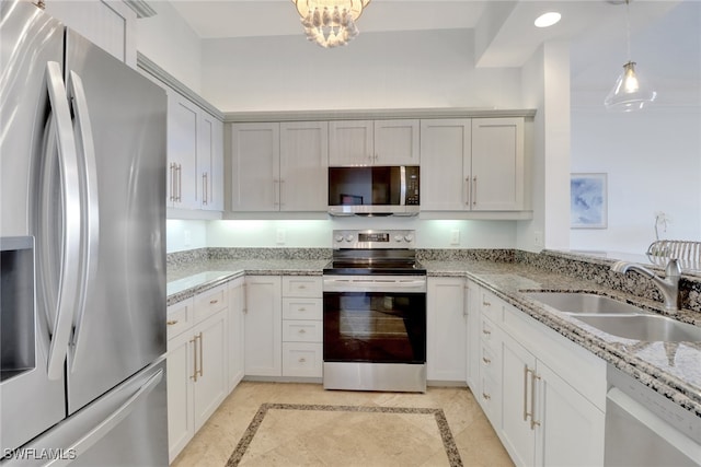 kitchen with sink, white cabinetry, light stone counters, decorative light fixtures, and stainless steel appliances