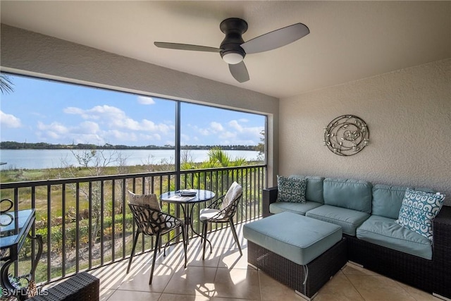 sunroom / solarium featuring a water view and ceiling fan