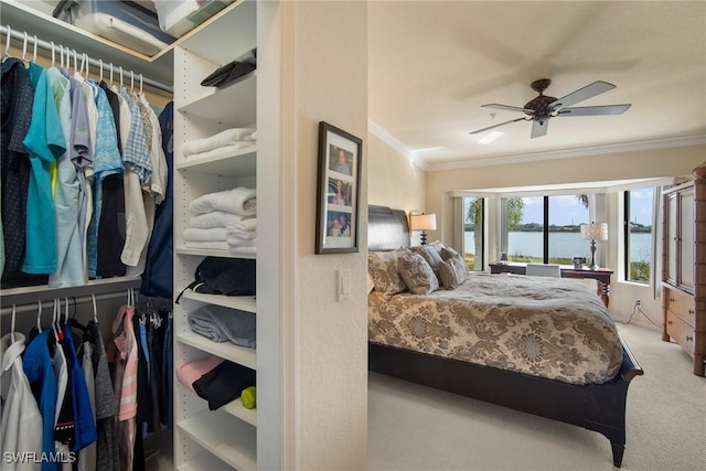 bedroom with a water view, ceiling fan, ornamental molding, and carpet flooring