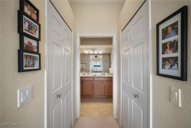 hall featuring sink and light tile patterned floors