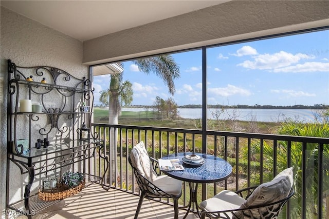 sunroom featuring a water view