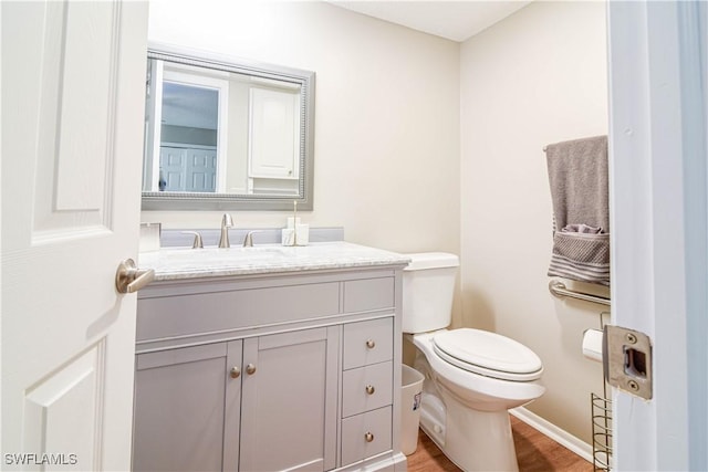 bathroom featuring vanity, hardwood / wood-style floors, and toilet