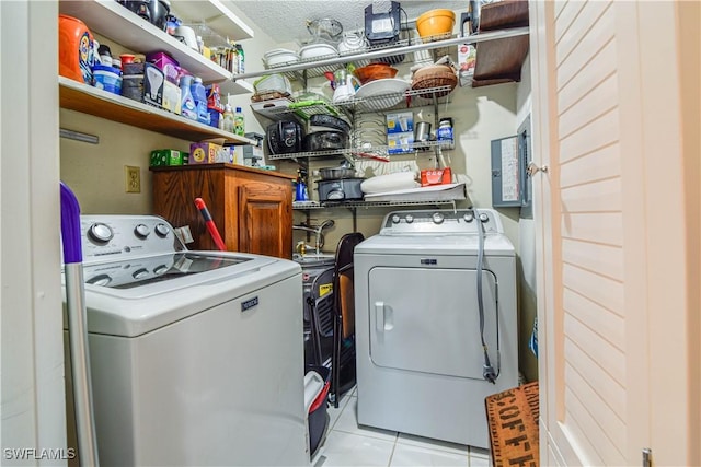 laundry area featuring light tile patterned flooring and washer and clothes dryer