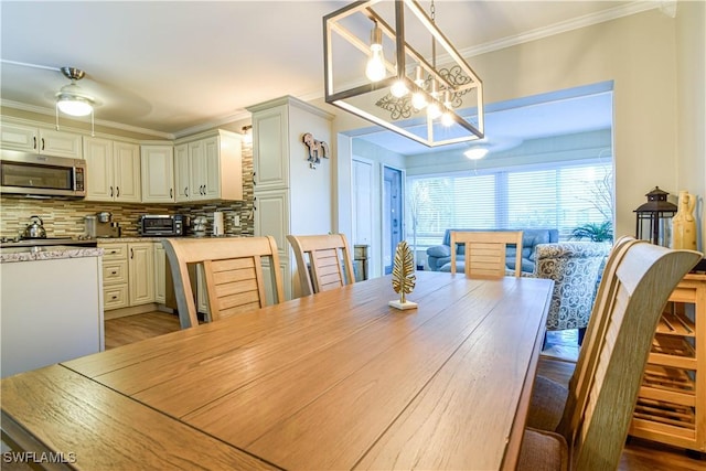 dining room featuring an inviting chandelier, wood-type flooring, and ornamental molding