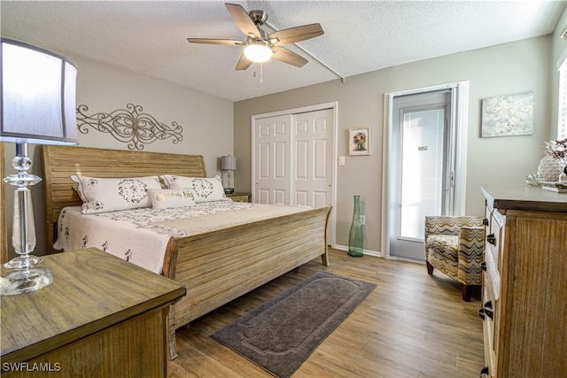 bedroom featuring hardwood / wood-style flooring, a closet, ceiling fan, and a textured ceiling