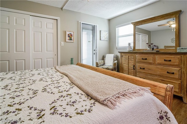 bedroom featuring ceiling fan, a closet, wood-type flooring, and a textured ceiling