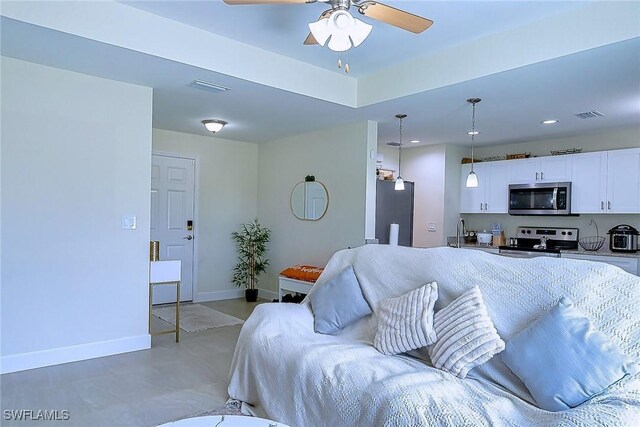 living room featuring a ceiling fan, recessed lighting, visible vents, and baseboards