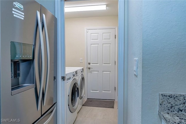 320 Ranch Ave, Lehigh Acres, FL 33974 - laundry room featuring a textured wall, light tile patterned floors, and independent washer and dryer
