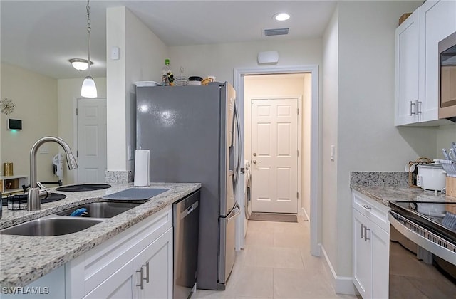 320 Ranch Ave, Lehigh Acres, FL 33974 - kitchen featuring a sink, stainless steel appliances, white cabinetry, light stone countertops, and pendant lighting