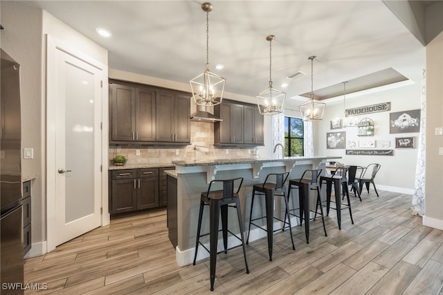 kitchen with dark brown cabinets, pendant lighting, and a kitchen breakfast bar