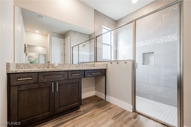 bathroom featuring vanity, hardwood / wood-style flooring, and walk in shower