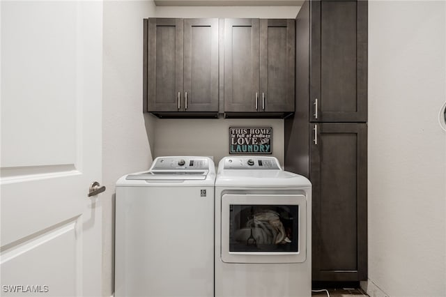 laundry area featuring washer and clothes dryer and cabinets