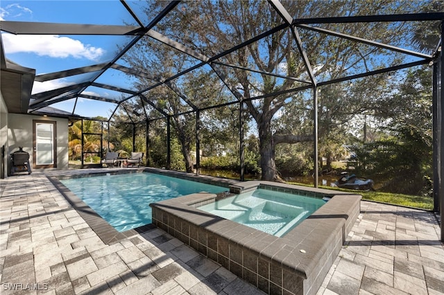 view of pool featuring a patio area, glass enclosure, and an in ground hot tub