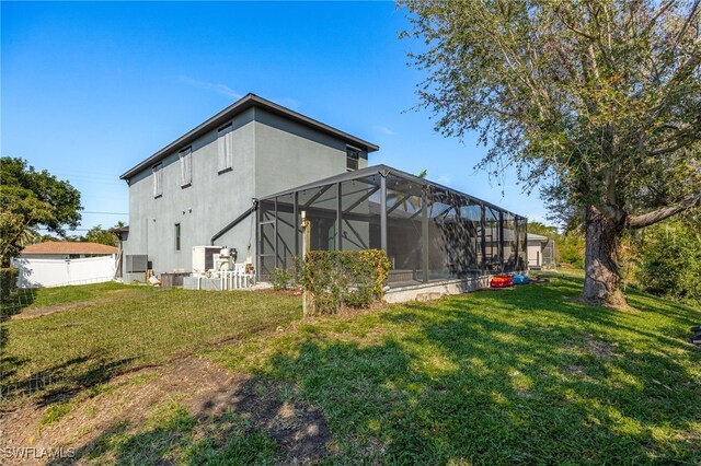 rear view of house with a lanai and a yard