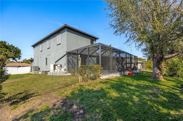 back of house featuring a lawn and glass enclosure