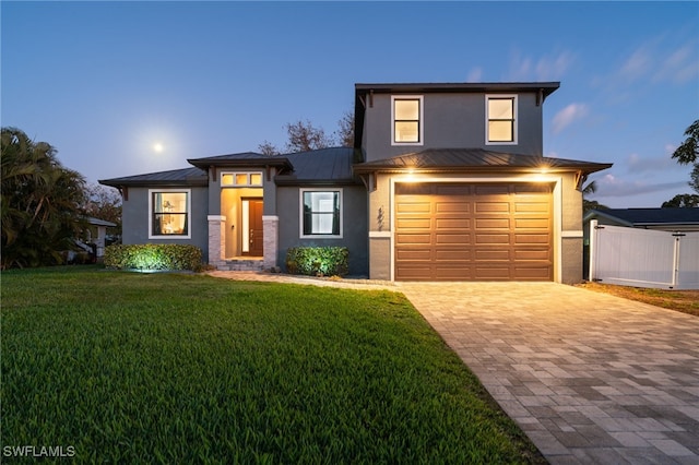 view of front of home featuring a garage and a lawn