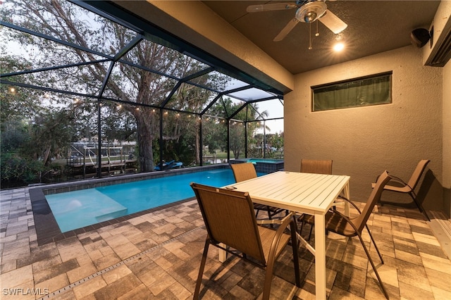 view of swimming pool with ceiling fan, a lanai, and a patio area