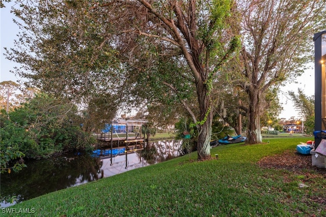 dock area featuring a water view and a lawn