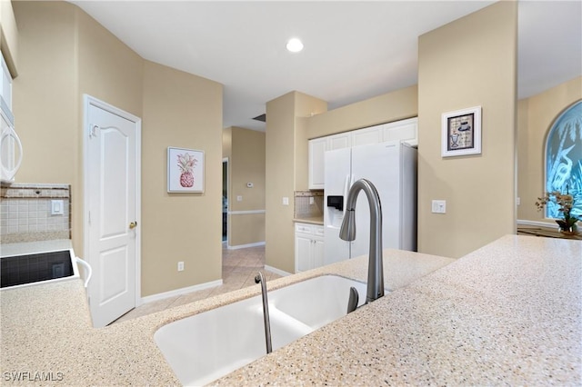 kitchen featuring white cabinetry, refrigerator with ice dispenser, decorative backsplash, kitchen peninsula, and electric stove