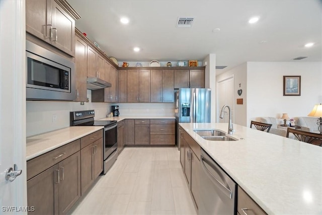 kitchen featuring stainless steel appliances, dark brown cabinets, and sink