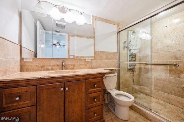 1400 Blue Point Ave Unit 207, Naples, FL 34102 - bathroom featuring vanity, a stall shower, toilet, tile walls, and decorative backsplash