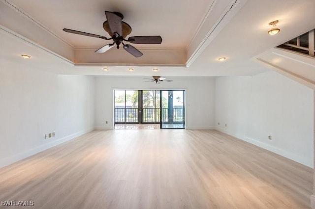 1400 Blue Point Ave Unit 207, Naples, FL 34102 - unfurnished living room featuring a tray ceiling, crown molding, light wood finished floors, baseboards, and a ceiling fan