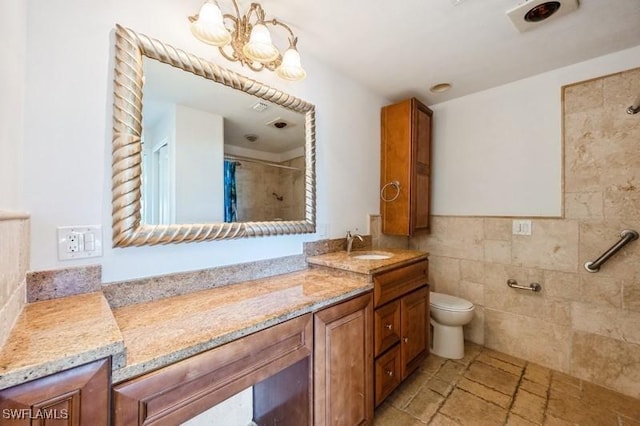 1400 Blue Point Ave Unit 207, Naples, FL 34102 - full bathroom featuring a tile shower, vanity, a chandelier, toilet, and tile walls