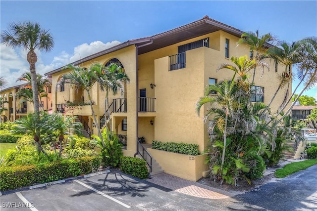 1400 Blue Point Ave Unit 207, Naples, FL 34102 - view of property with uncovered parking and stairway