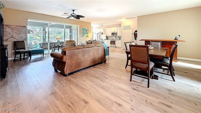 living room with ceiling fan and light hardwood / wood-style flooring