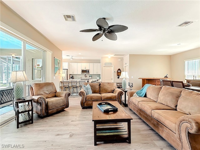 living room featuring ceiling fan and light hardwood / wood-style flooring