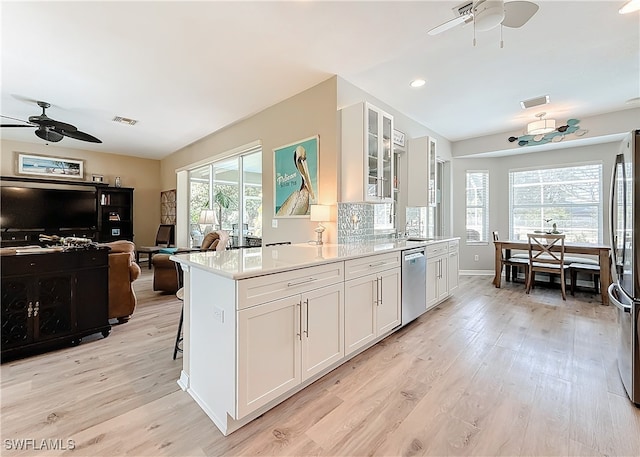 kitchen with white cabinetry, stainless steel appliances, light hardwood / wood-style floors, and ceiling fan