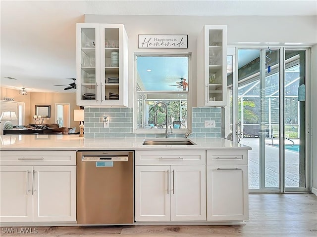 bar with tasteful backsplash, dishwasher, sink, white cabinets, and ceiling fan