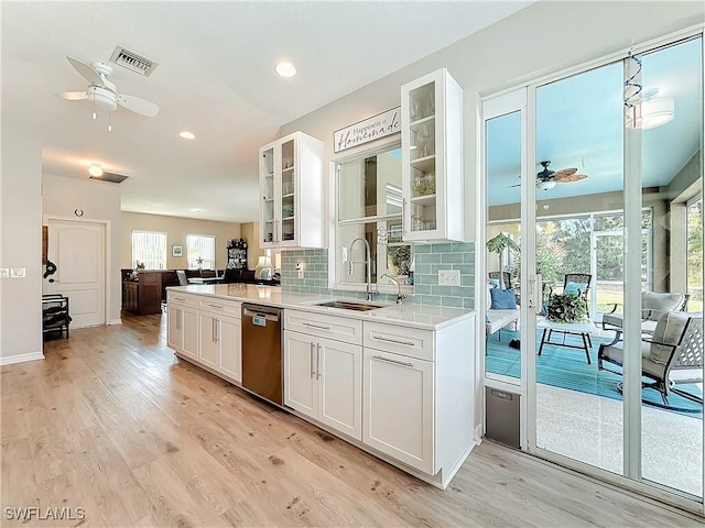 kitchen featuring white cabinetry, dishwasher, sink, backsplash, and light hardwood / wood-style floors