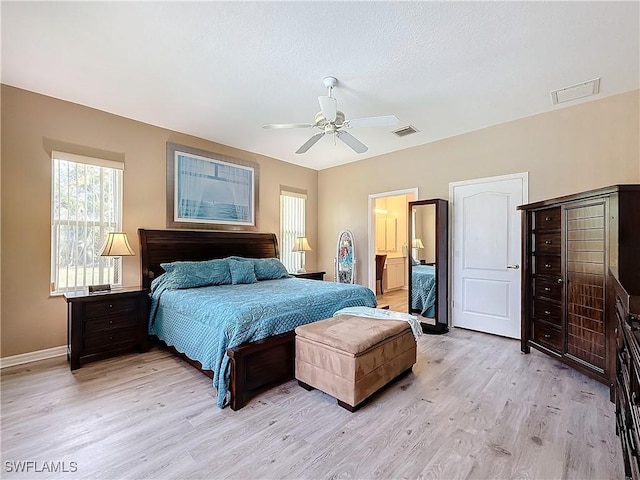 bedroom featuring ceiling fan, ensuite bathroom, and light hardwood / wood-style flooring