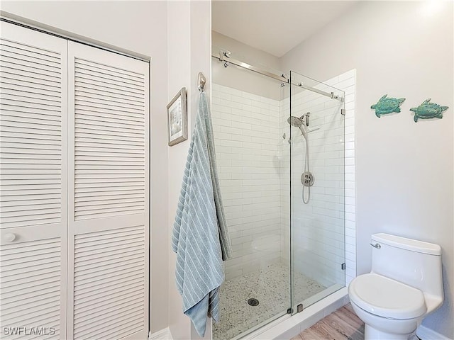 bathroom with toilet and a shower with door