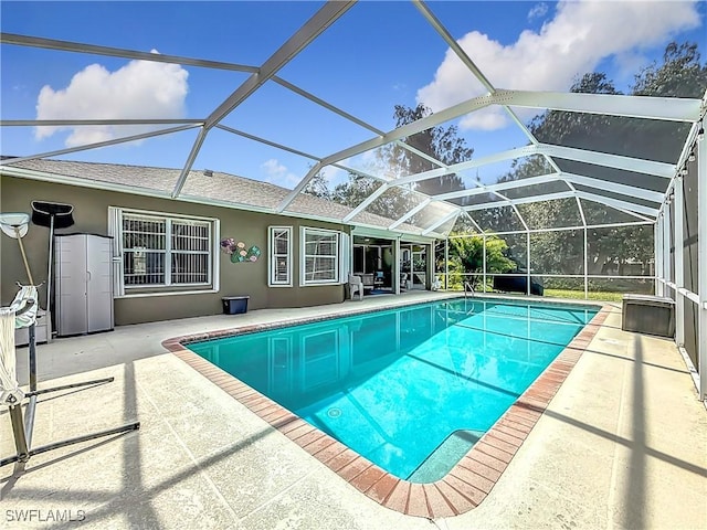 view of swimming pool featuring a lanai and a patio