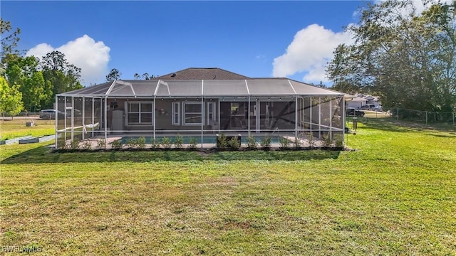 rear view of house with a lanai and a lawn