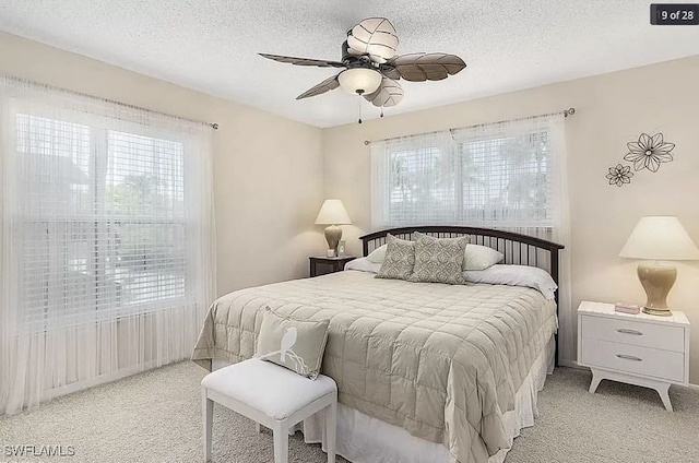 carpeted bedroom with ceiling fan and a textured ceiling