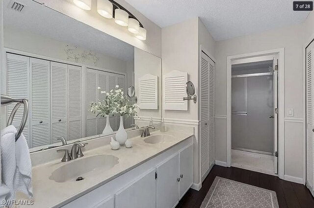 bathroom with hardwood / wood-style flooring, vanity, and a textured ceiling