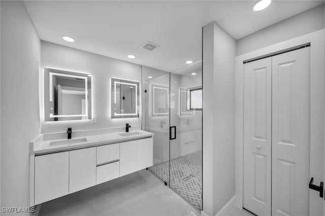 bathroom with vanity and a shower with door