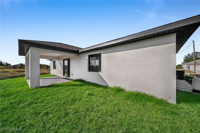 back of property with a yard and a patio