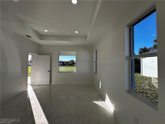 unfurnished room with a tray ceiling