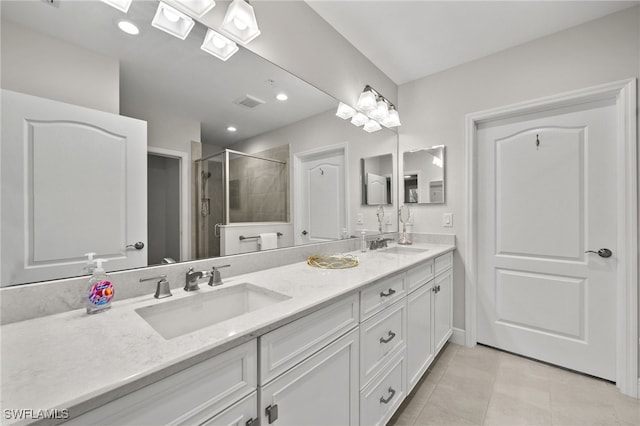 bathroom featuring a shower with door, vanity, and tile patterned floors