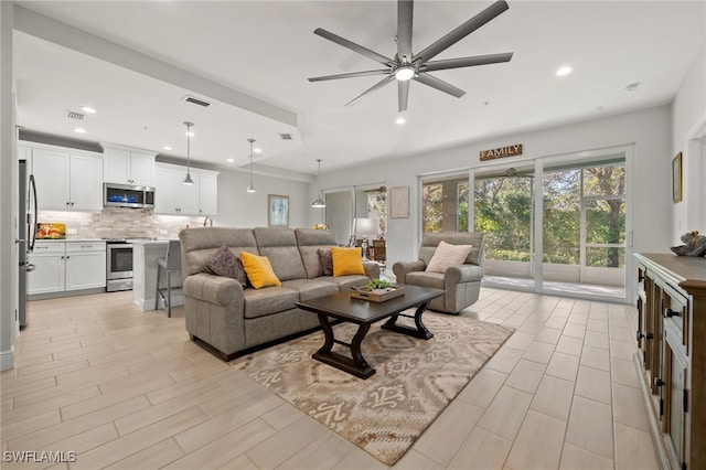 living room featuring ceiling fan and light hardwood / wood-style flooring