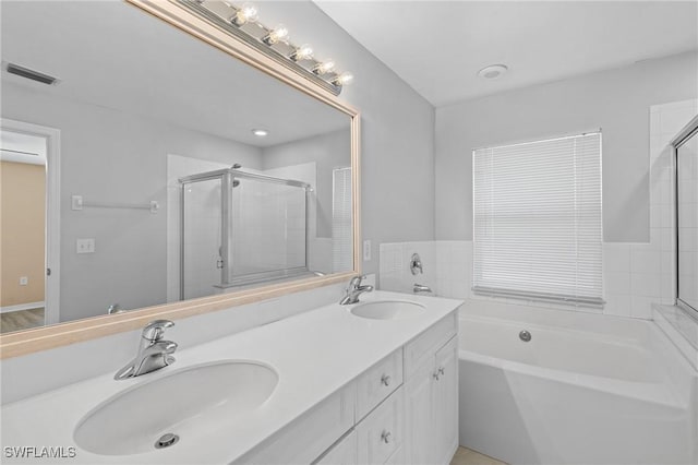 bathroom featuring a garden tub, a sink, visible vents, and a shower stall